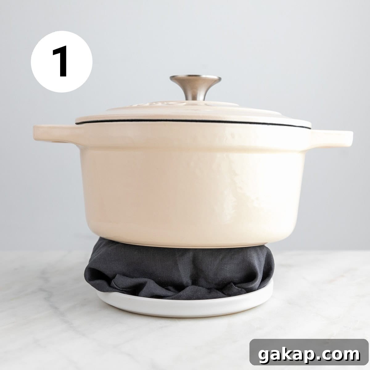 Tofu wrapped in a clean towel on a plate with a pot on top.