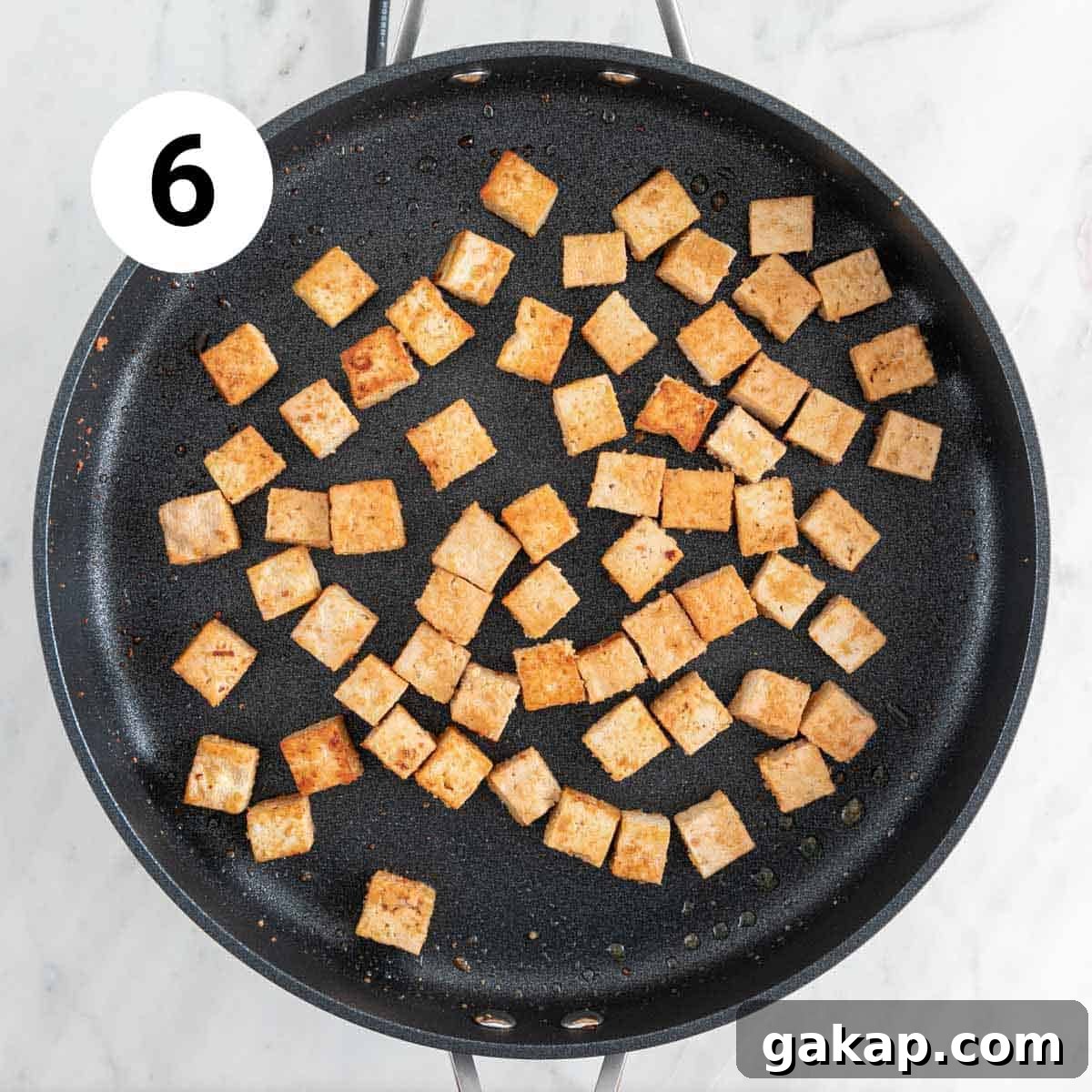 Sautéed tofu cubes in a skillet.