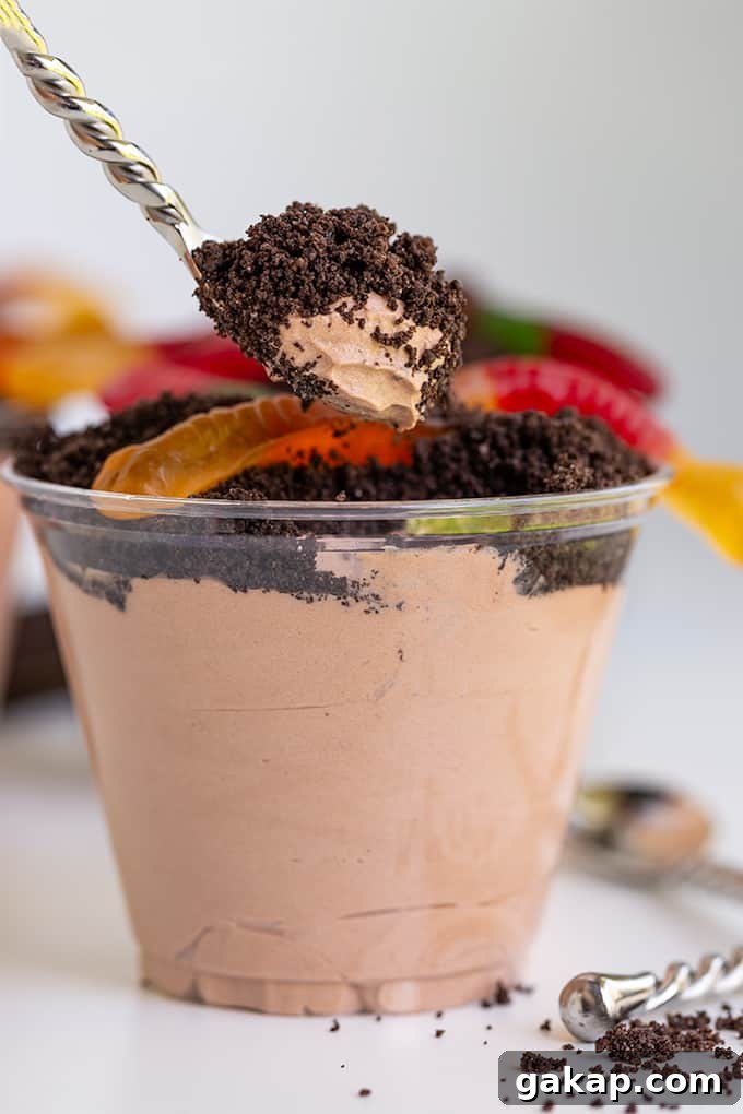 No-Bake Dirt Cake Cups Recipe — Creamy Chocolate Pudding Cups 4 spoon holding a scoop of dirt cake