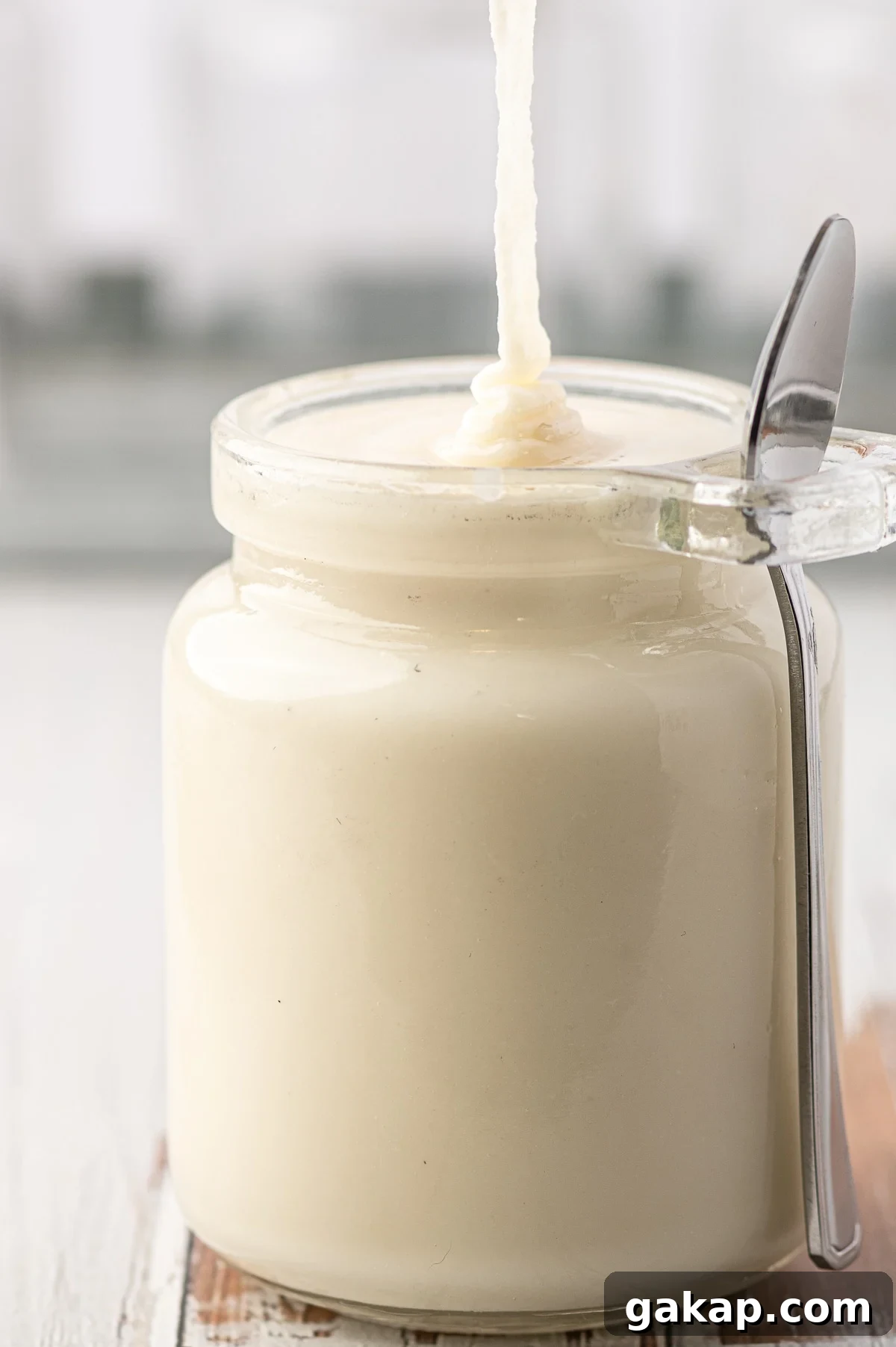 Top Nut Butters for Low-Carb Baking: Almond, Peanut & More 5 Just made low carb coconut butter being poured into a glass jar against a grey background