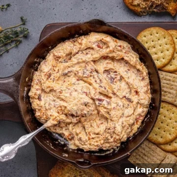 Baked Boursin dip with crackers on a wooden board.