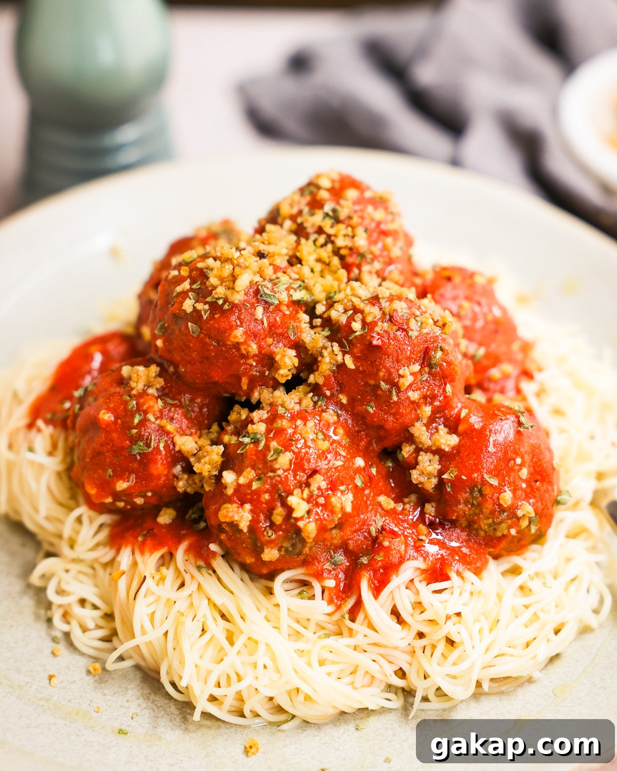 vegan meatballs stacked on a bed of spaghetti