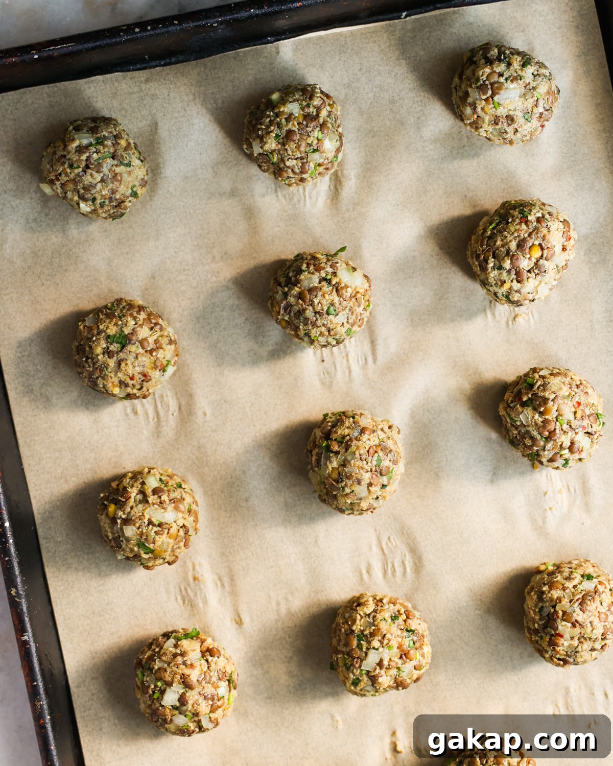 Uncooked vegan meatballs on baking sheet.