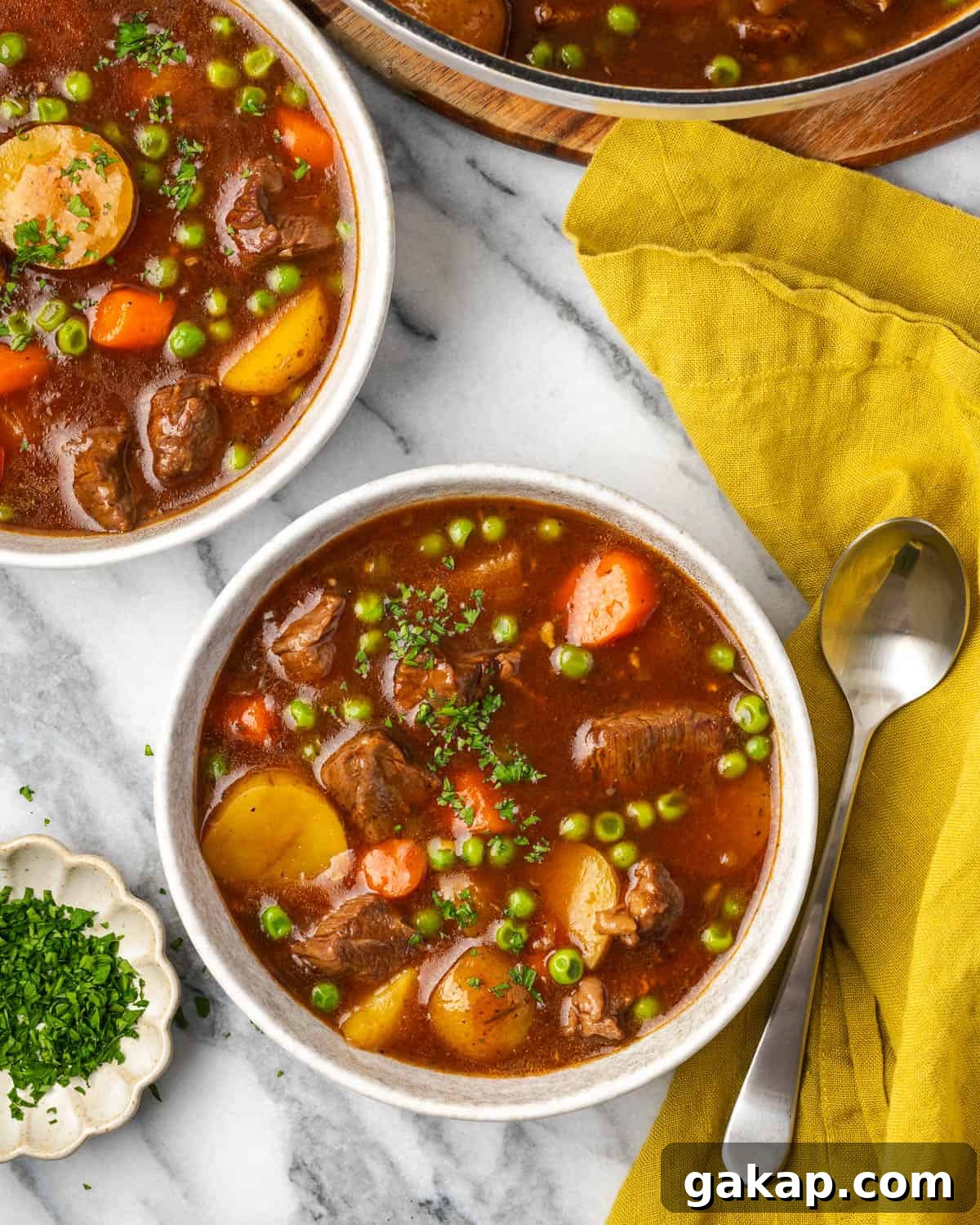 Two bowls of beef stew on a marble counter. 