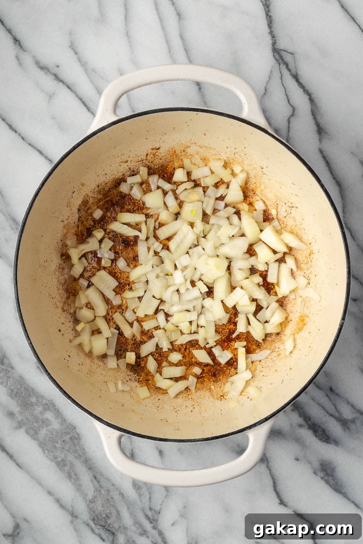 Onions being sauteed in a large pot. 