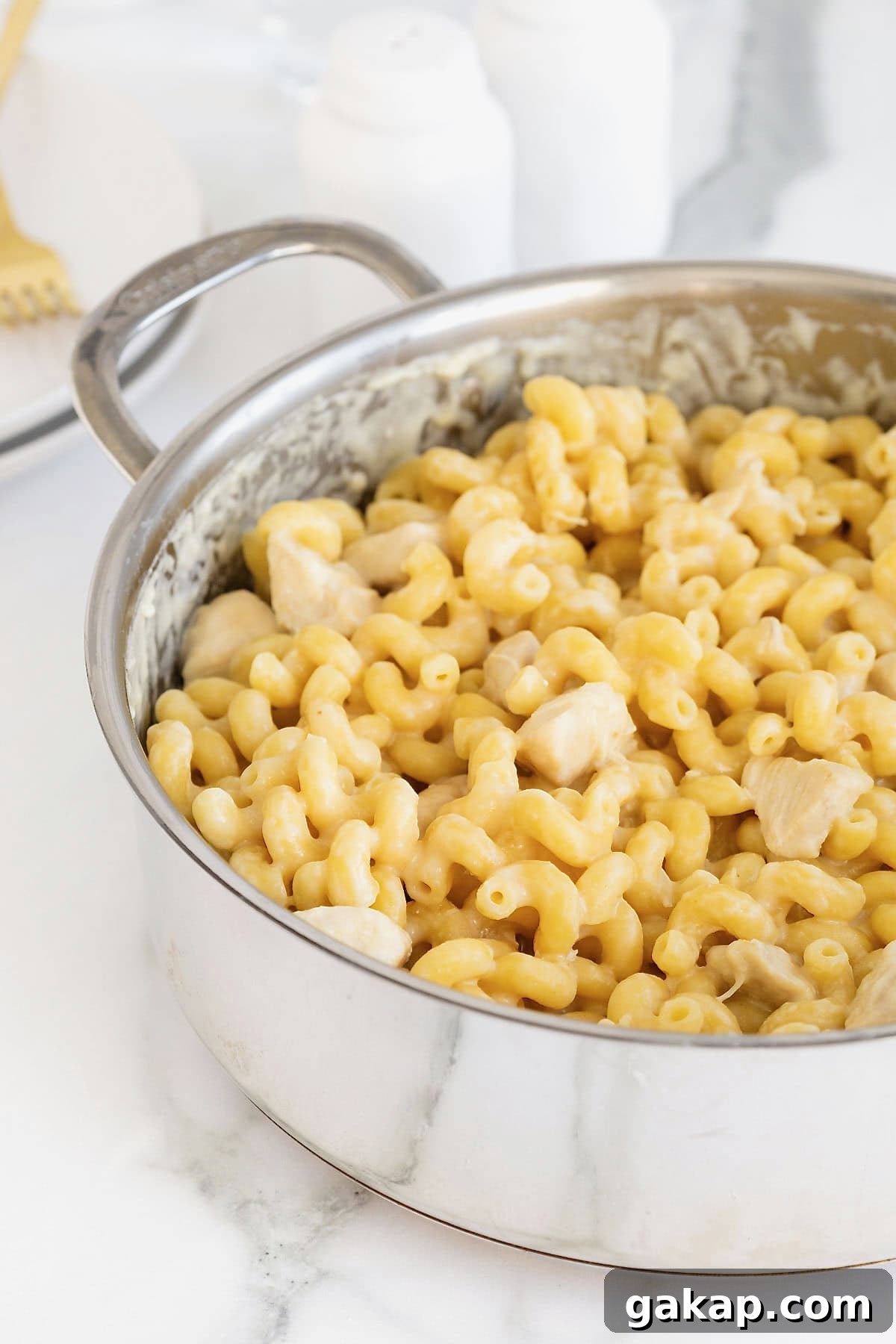 A stainless steel pot of chicken Alfredo with cavatappi pasta.