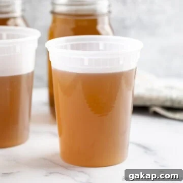 Homemade vegetable stock in a storage containers.