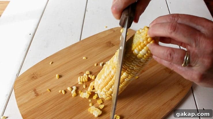 Cutting corn kernels off a cob.
