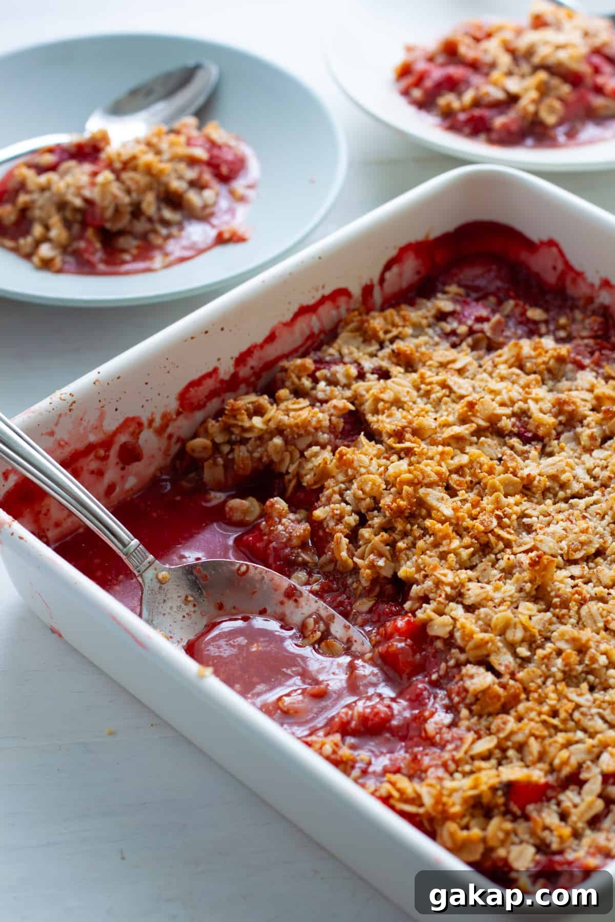 Strawberry crumble with a scoop taken out and put on a small plate.