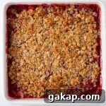 A cooked strawberry crumble in a baking dish.