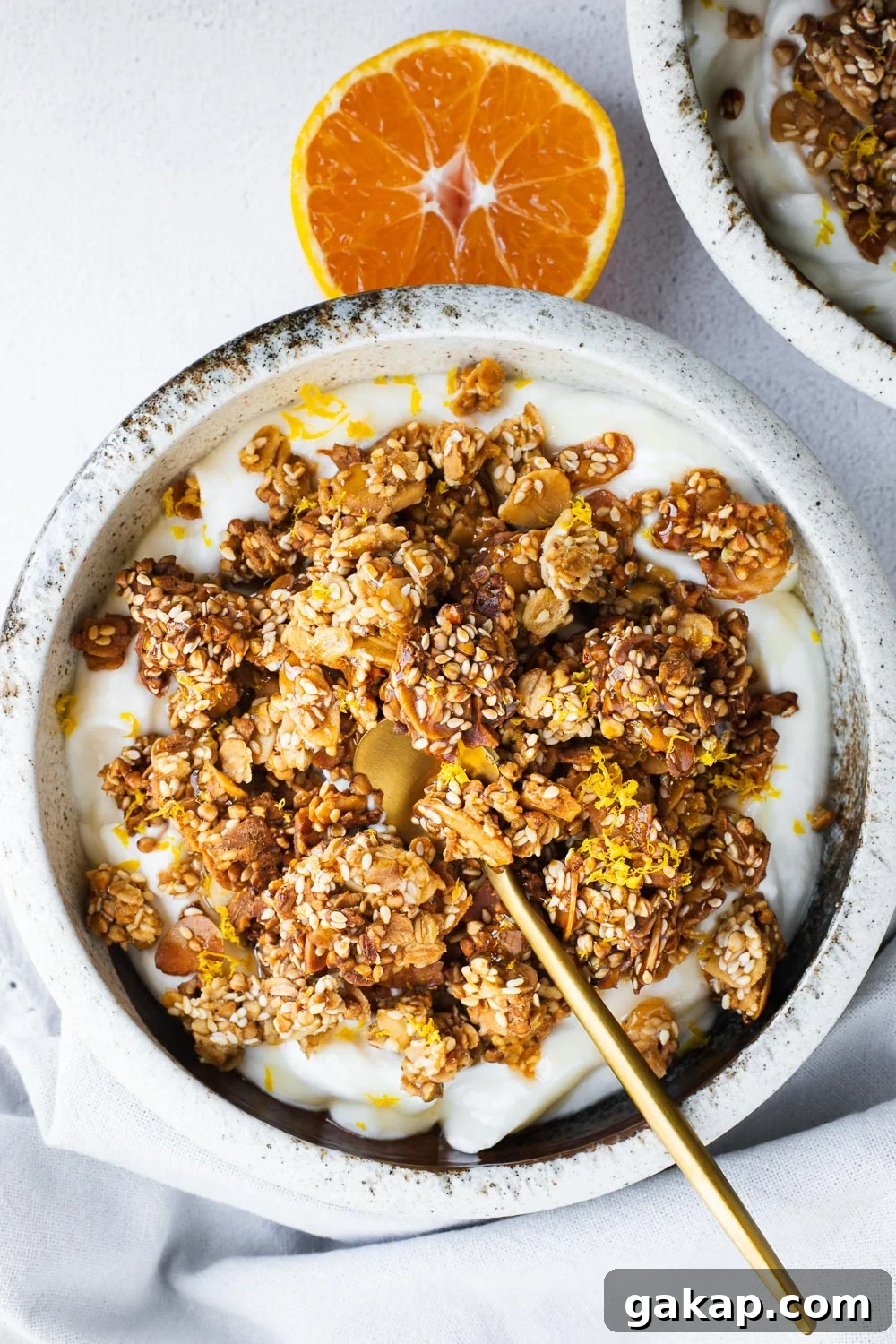 Tahini Sesame Granola with Honey and Orange Zest 2 Homemade tahini granola with orange and honey, served in a bowl with yoghurt.