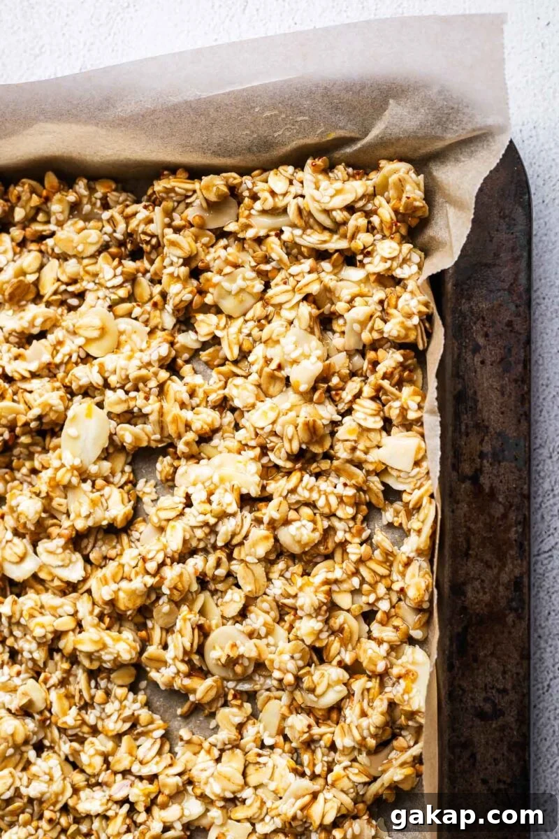 Tahini Sesame Granola with Honey and Orange Zest 6 Close-up of unbaked granola mix in a baking tray.