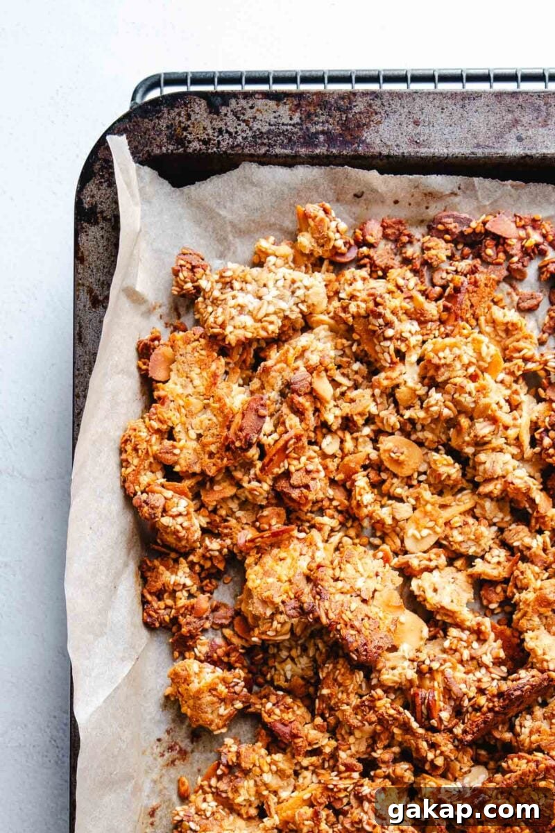 Tahini Sesame Granola with Honey and Orange Zest 7 Wholesome granola baked on parchment paper.