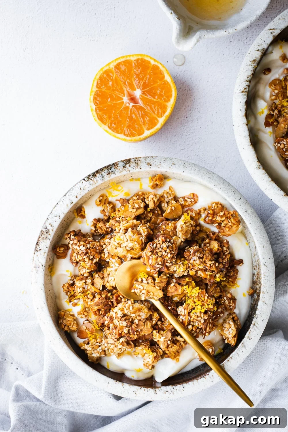 Tahini Sesame Granola with Honey and Orange Zest 9 Tahini granola bowls with with yoghurt, orange and honey viewed from top down.