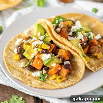 Two sweet potato tacos with black beans on plate.