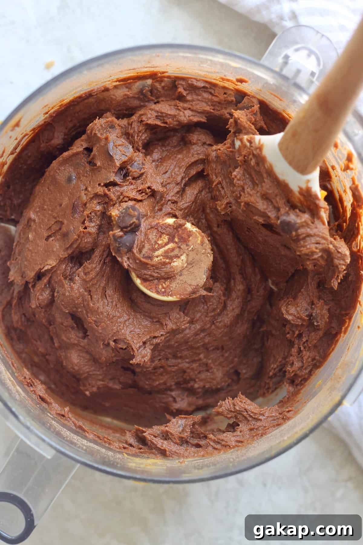 food proccesor with brownie batter and spatula.