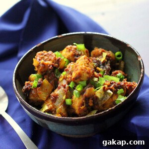 Keralan Tempeh Chili Roast in a black bowl on a blue cloth