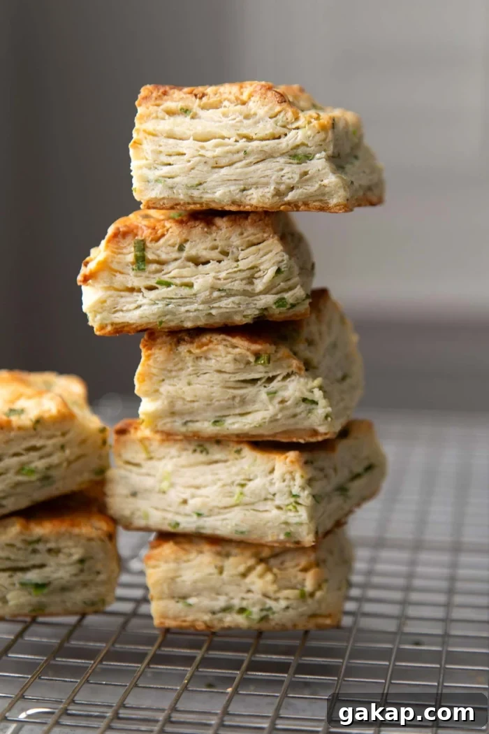 five ranch scallion biscuits stacked on top of each other on wire rack.