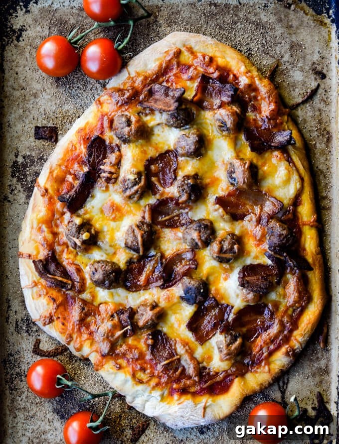 Crispy-Chewy Homemade Pizza Dough Recipe for Perfect Crust 8 A cooked all-meat pizza on a pizza stone with cherry tomatoes scatter around.