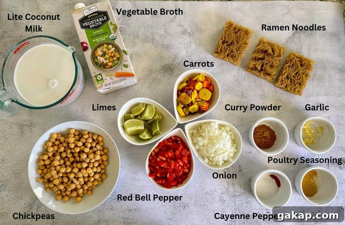Soup ingredients: light coconut milk vegetable broth, ramen noodles, garlic, curry powder, cayenne pepper, poultry seasoning, red bell pepper, onion, carrots, limes, and chickpeas.