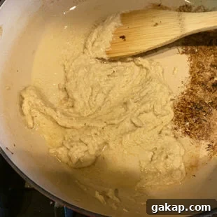 Black Pepper Paneer (Paneer Kali Mirch) — Spicy Indian Cottage Cheese 12 pan with a ground white paste with a wooden spatula