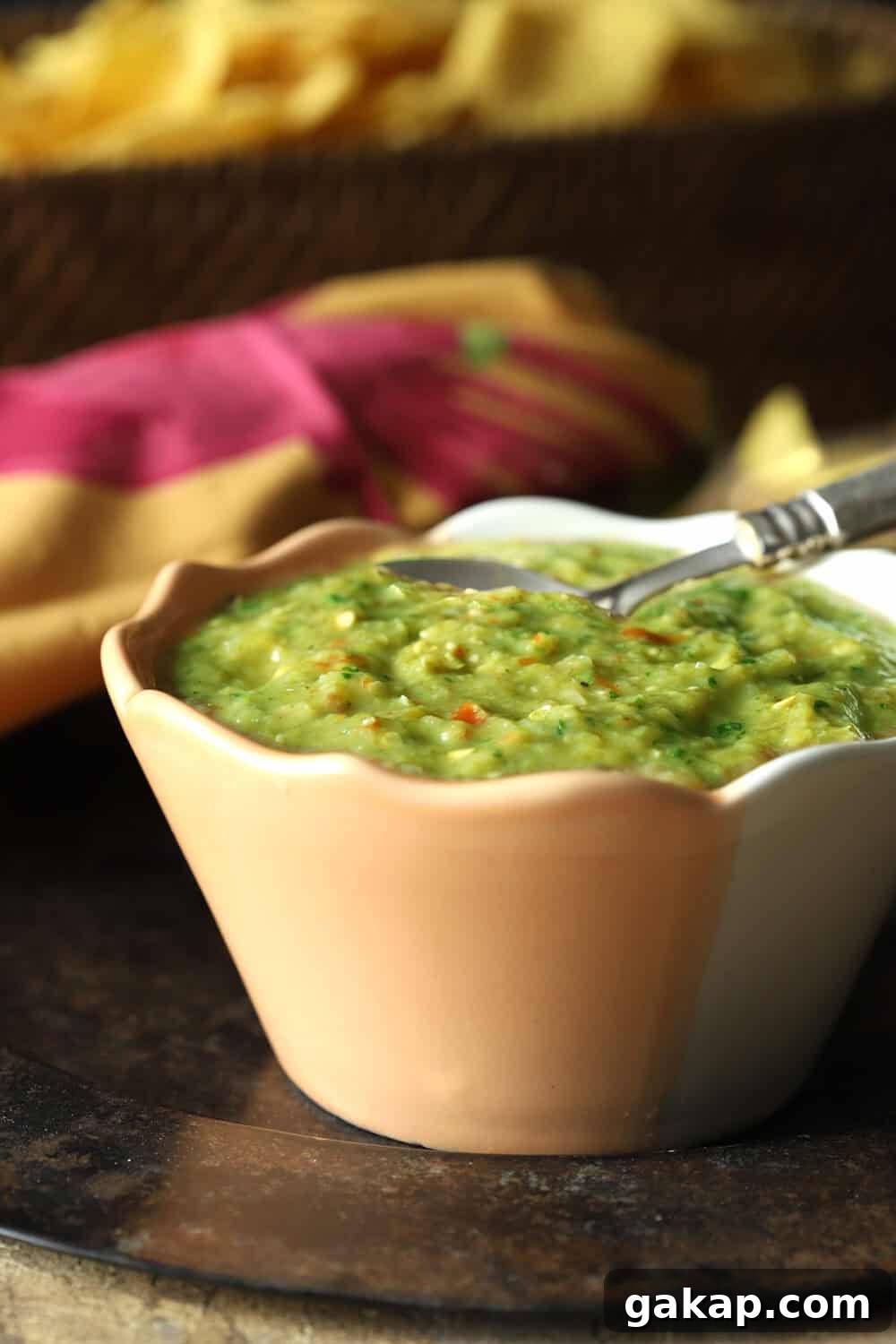 Tomatillo Salsa Verde is a green salsa shown in a light orange serving bowl.