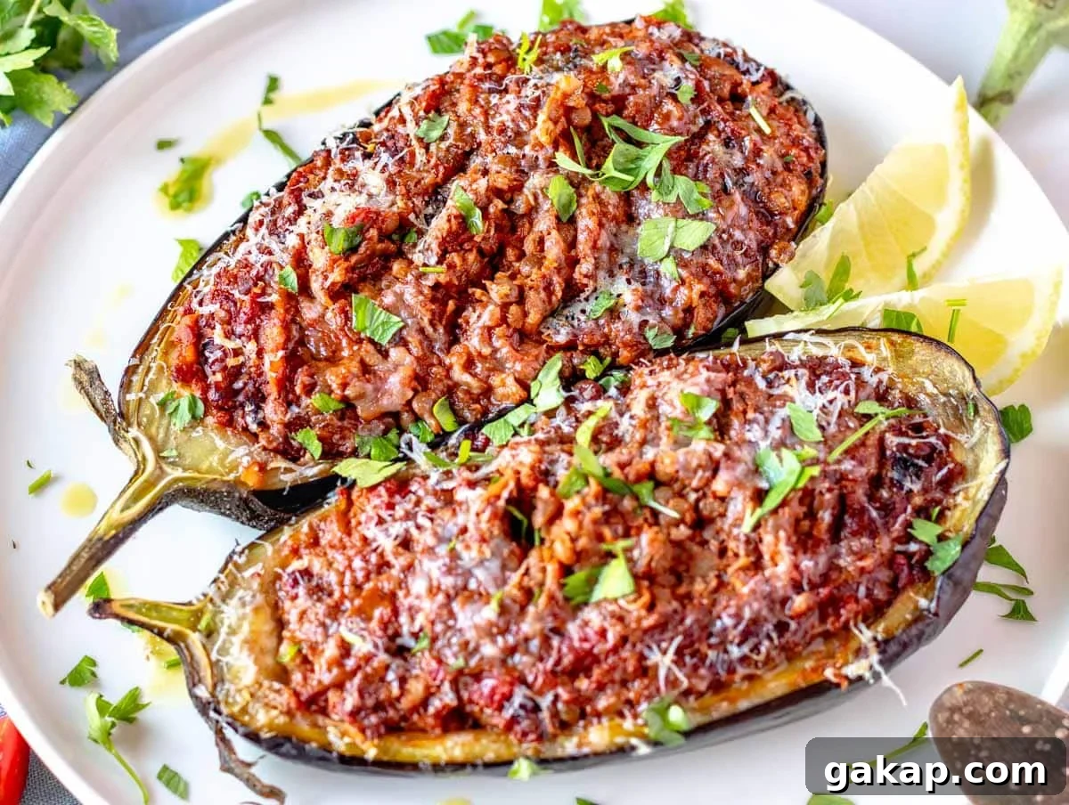 Stuffed eggplant with parmesan and fresh parsley on a white plate