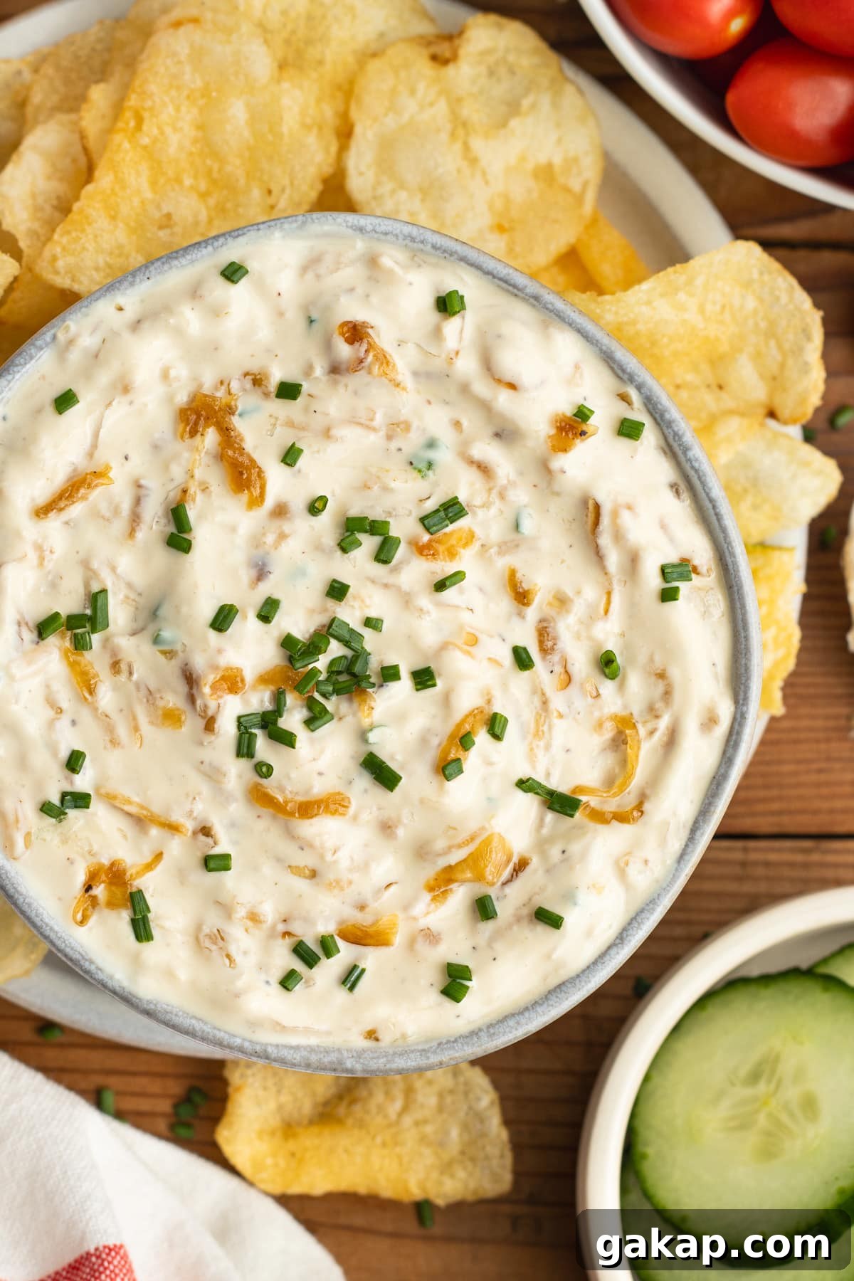 This is a picture of the caramelized onion dip with greek yogurt surrounded with chips and veggies.