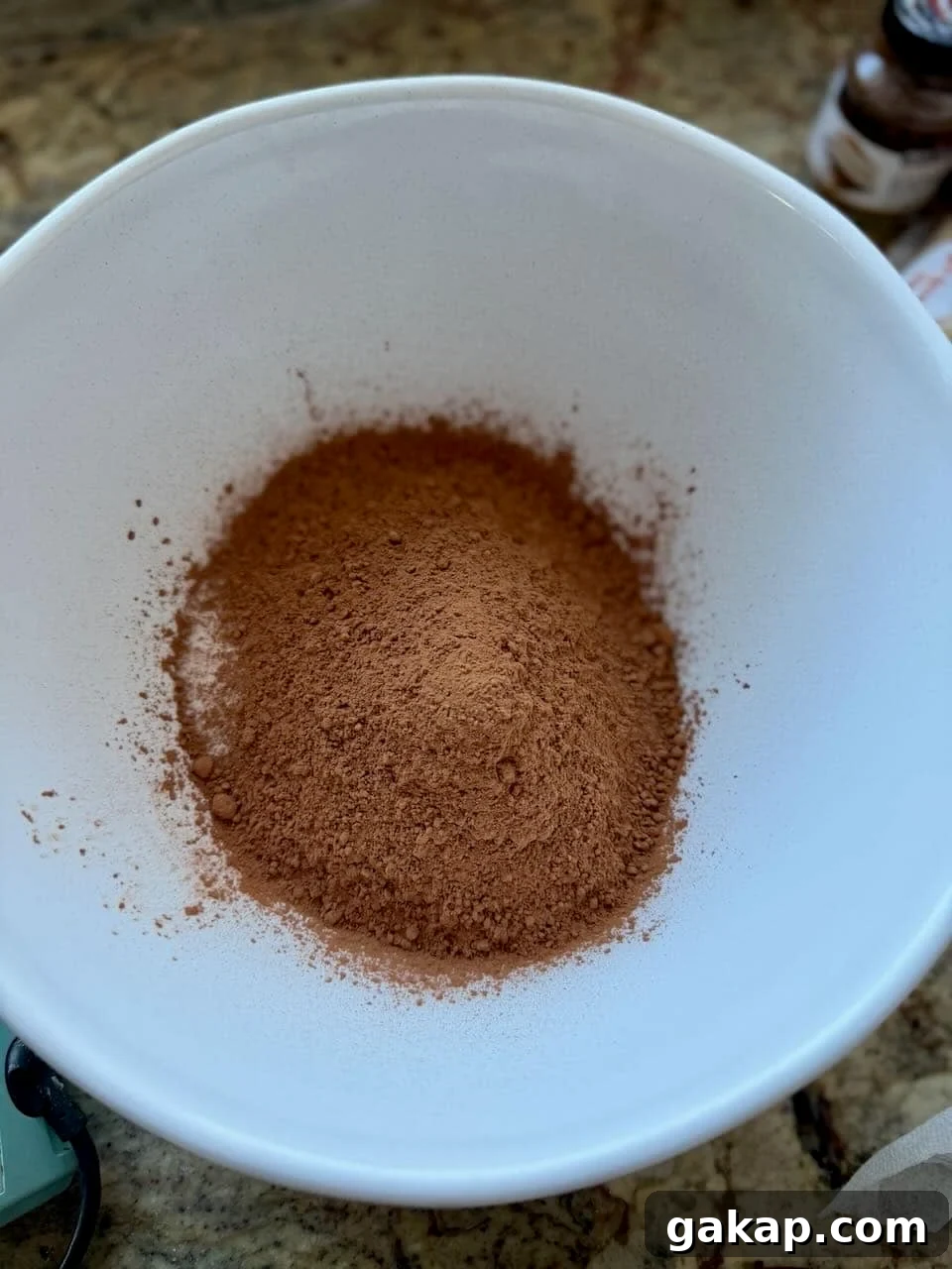 Cocoa powder, espresso powder, and dry ingredients combined together in a mixing bowl.