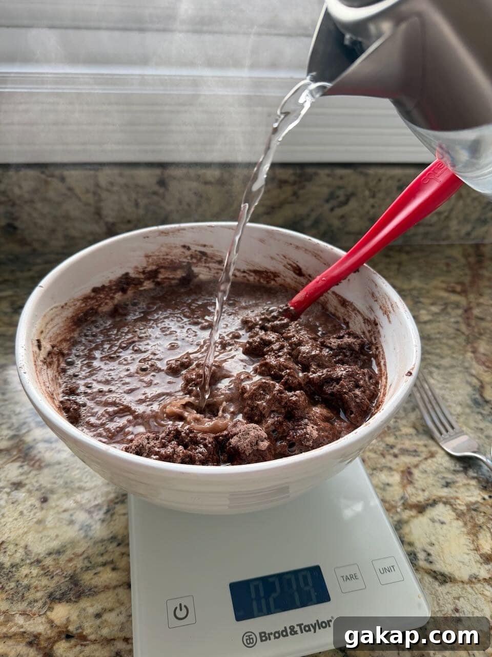 Hot water being poured into the cocoa mixture to bloom the chocolate flavor.