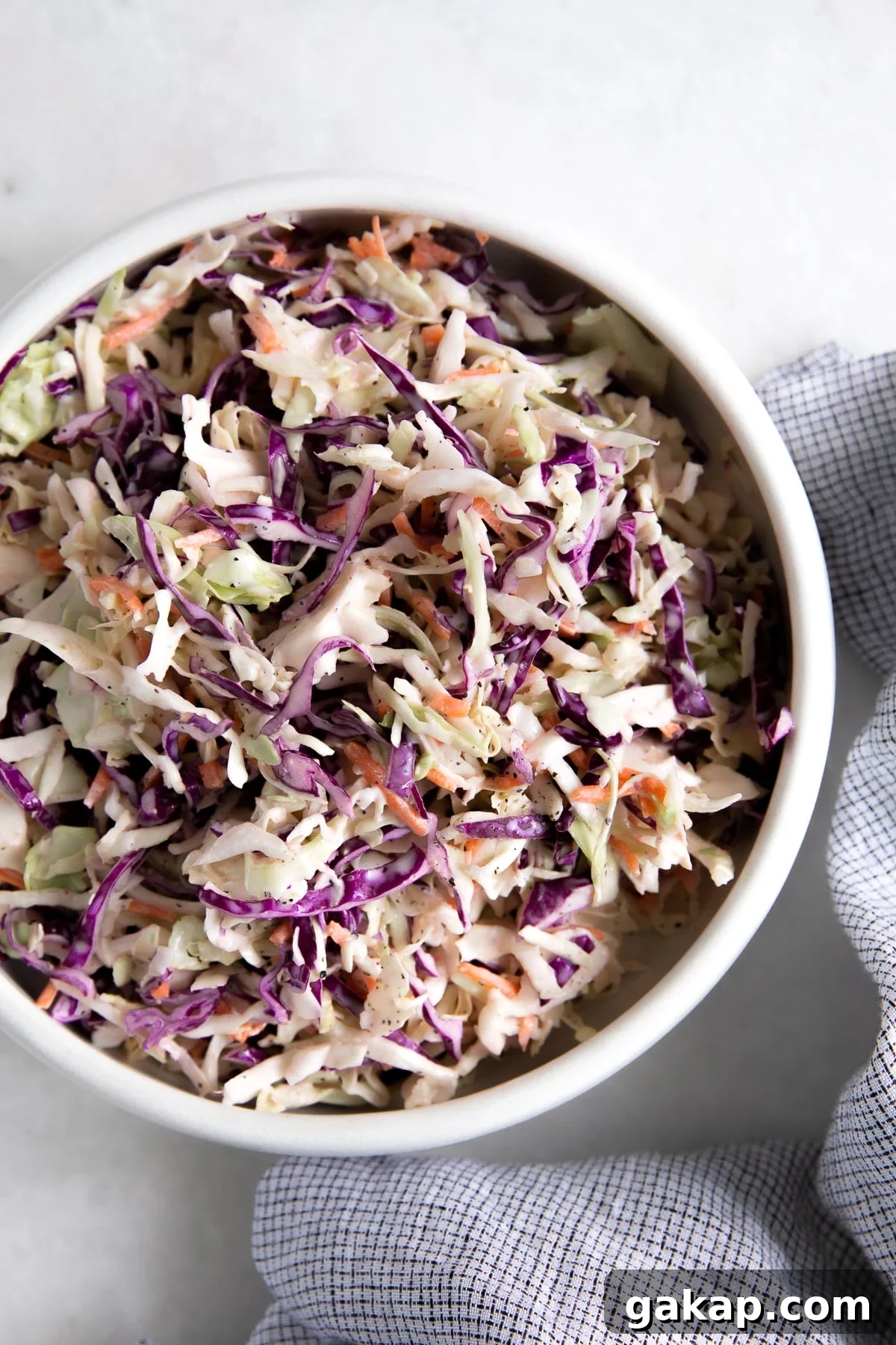 Creamy classic coleslaw in a large white bowl.