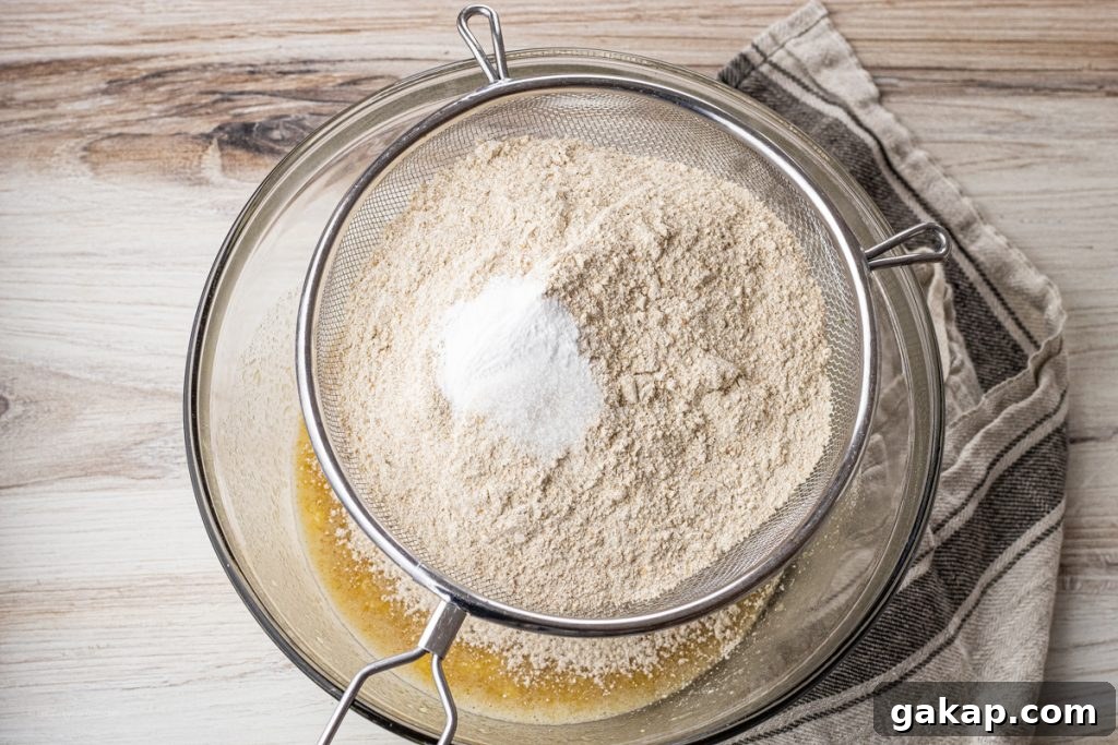 Moist Whole Wheat Banana Bread with Walnuts and Cinnamon 4 sifting dry ingredients into over a mixing bowl through a wire sifter