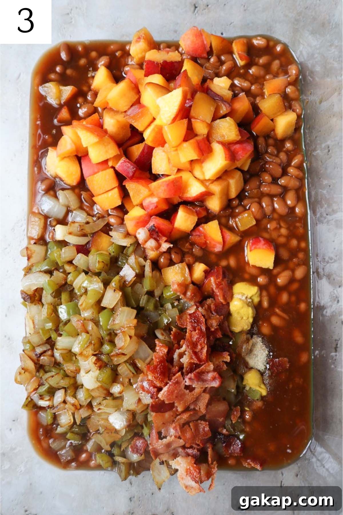 Chipotle Peach Baked Beans Recipe for Sweet-Spicy BBQ Sides 6 glass baking dish with ingredients to make peach baked beans.