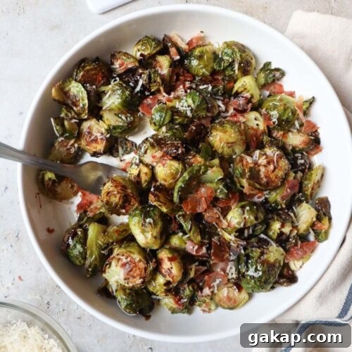 white bowl with brussels sprouts, parmesan cheese, prosciutto, and balsamic glaze.