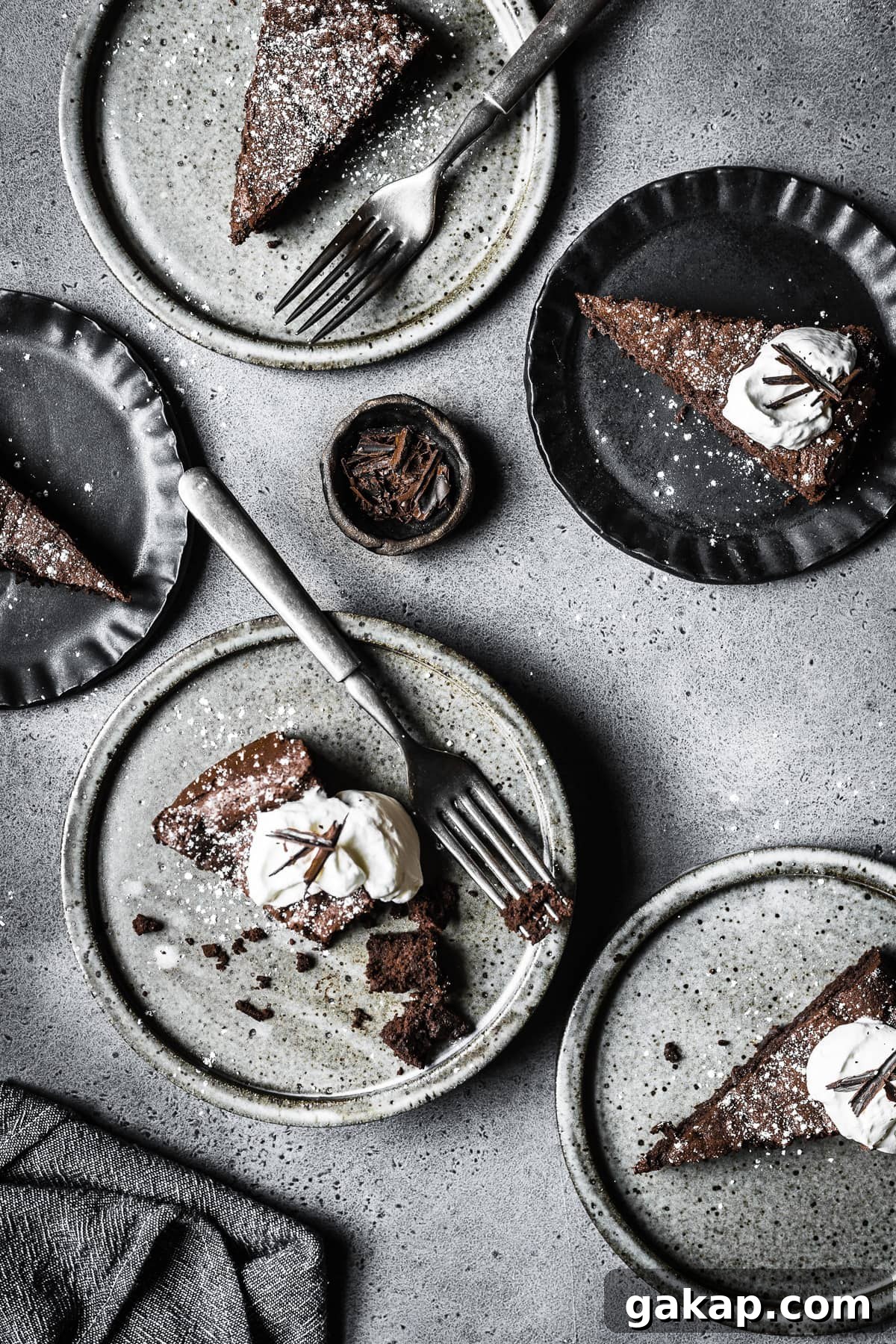 Five slices of torta tenerina on grey and black plates.