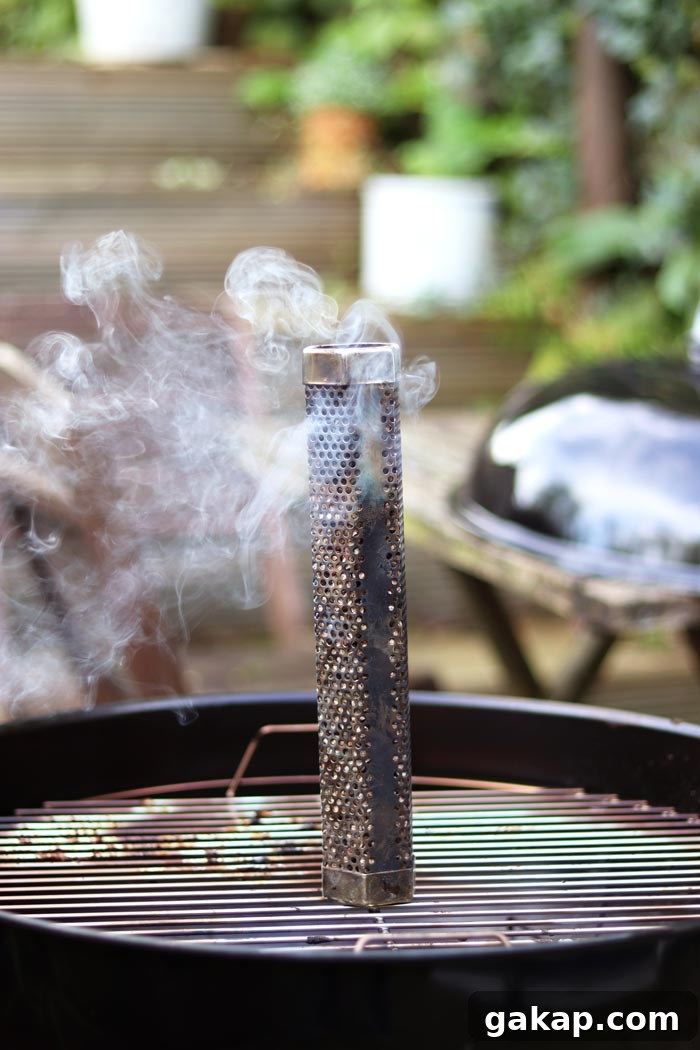 pellet smoke tube sat on grill grates with smoke billowing out