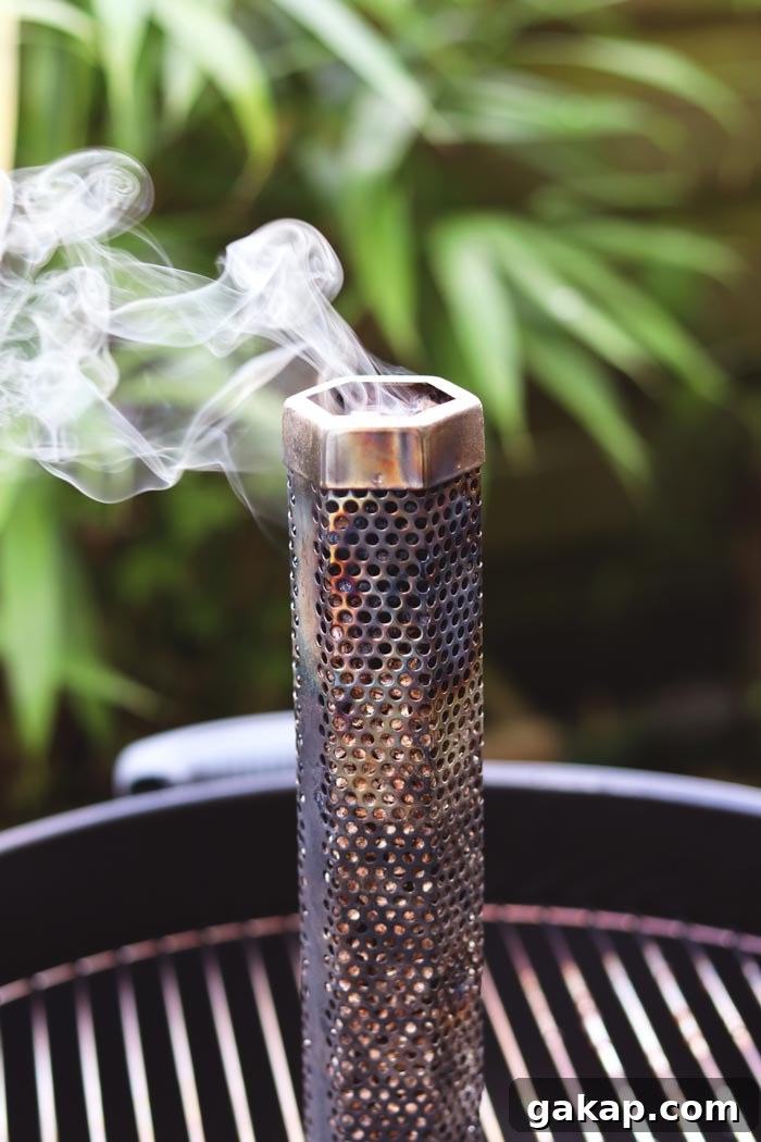 close-up of lit pellet smoke tube billowing smoke for barbecue