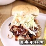 Smoky Pulled Pork Sandwiches with Tangy Barbecue Sauce 2 pulled pork bbq sandwich with coleslaw on a bun