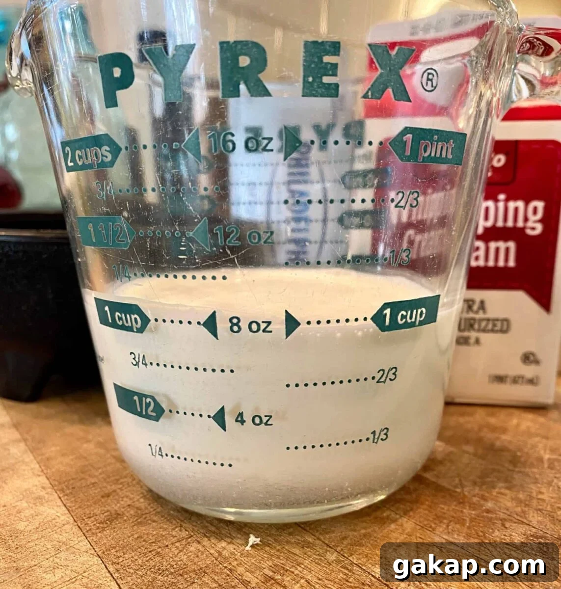 One cup of whipping cream in a glass measuring cup
