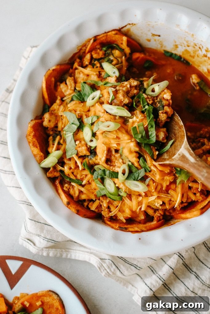 enchilada sweet potato casserole in a baking dish with wood spoon