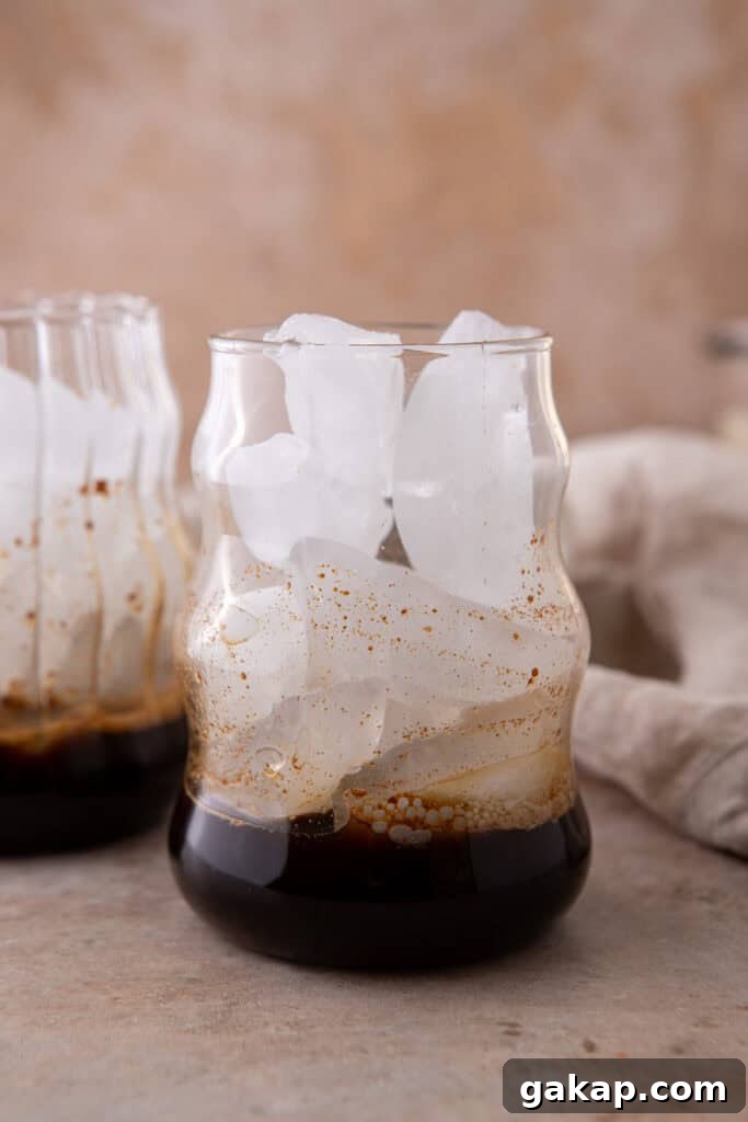 Honey Oatmilk Latte Recipe: Hot & Iced Starbucks-Style Guide 5 Espresso and ice in a glass, showing the base layer for an iced honey oat milk latte.