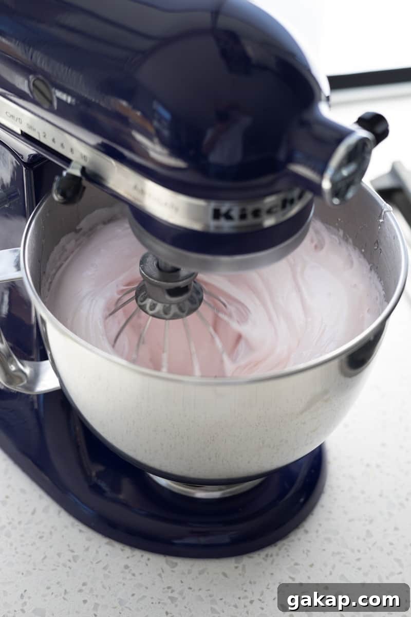 Marshmallow mixing in a stand mixer.