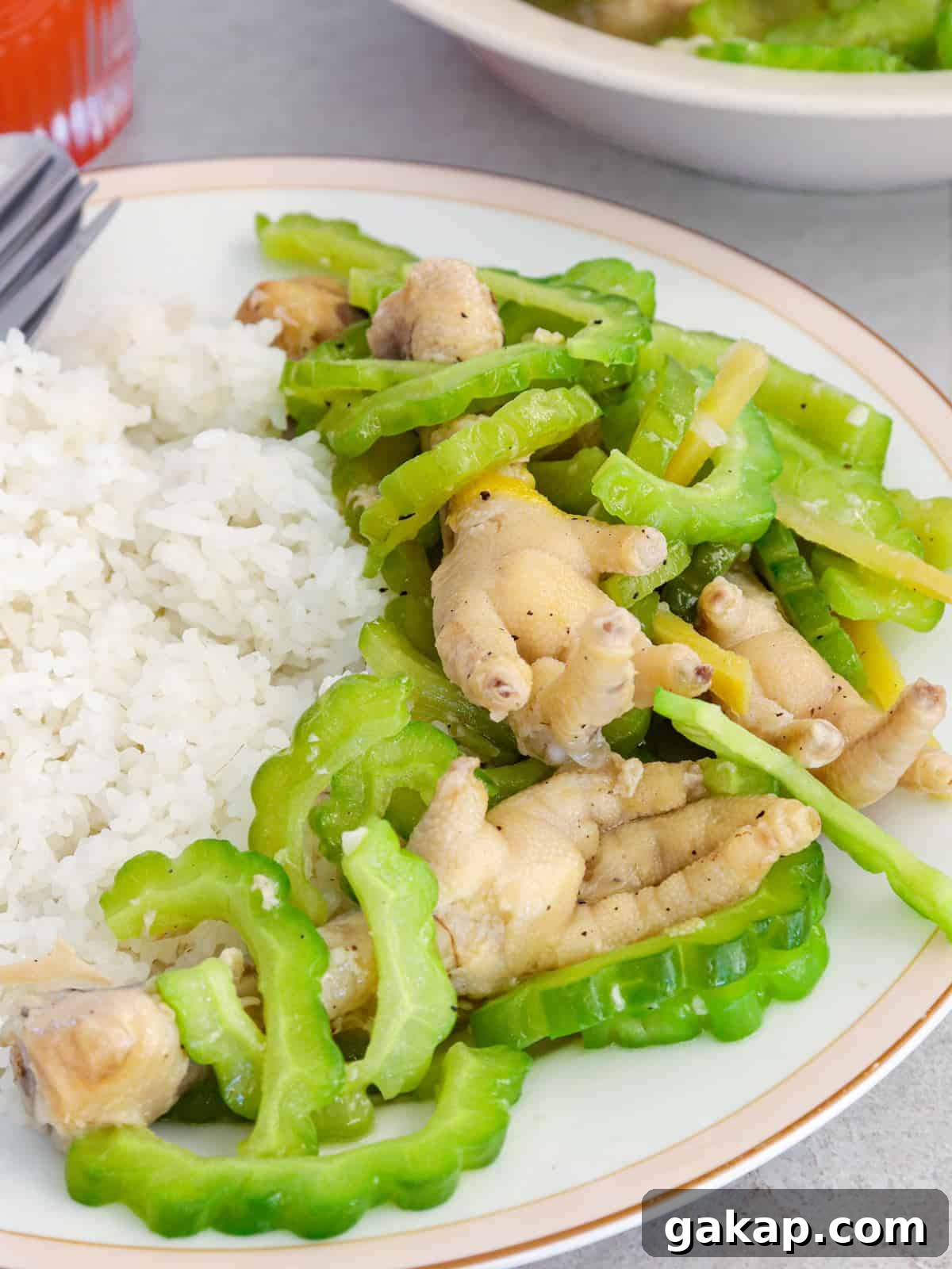 Bitter Melon with Chicken Feet Recipe: Filipino Style Stew 6 Ampalaya with Chicken Feet on a white plate with steamed rice.