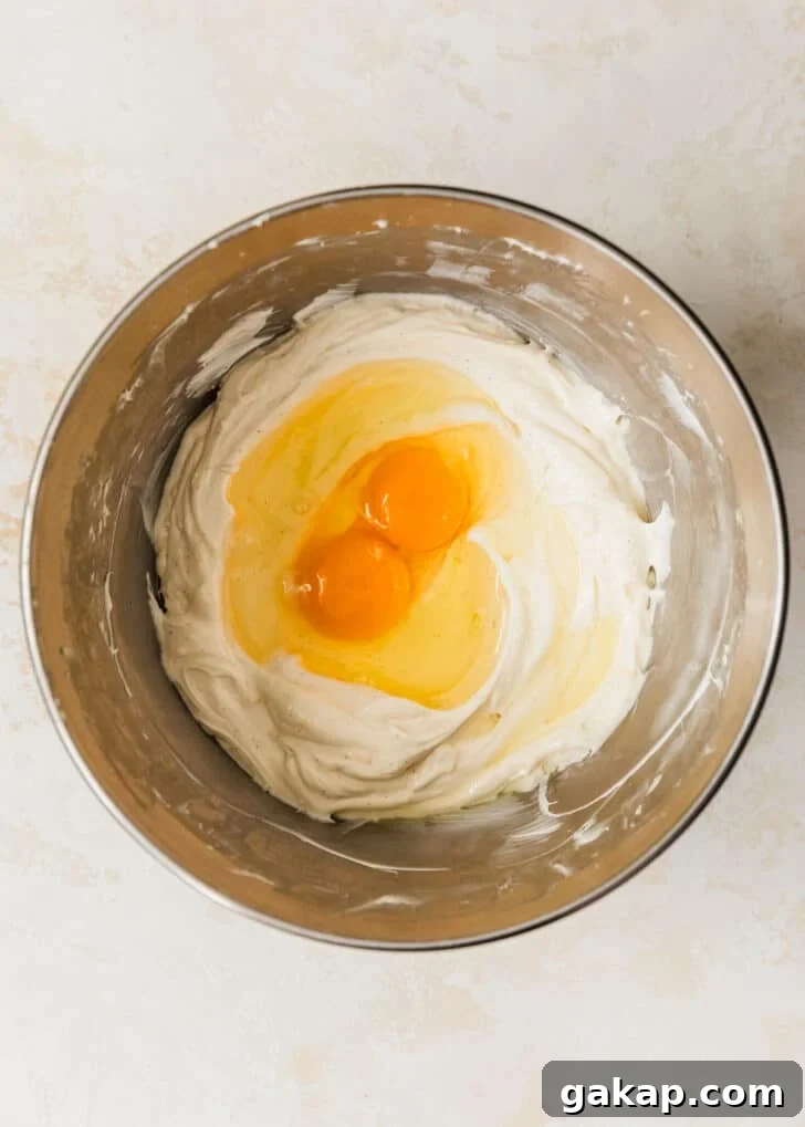 A silver bowl of cream cheese and eggs on a tan counter.