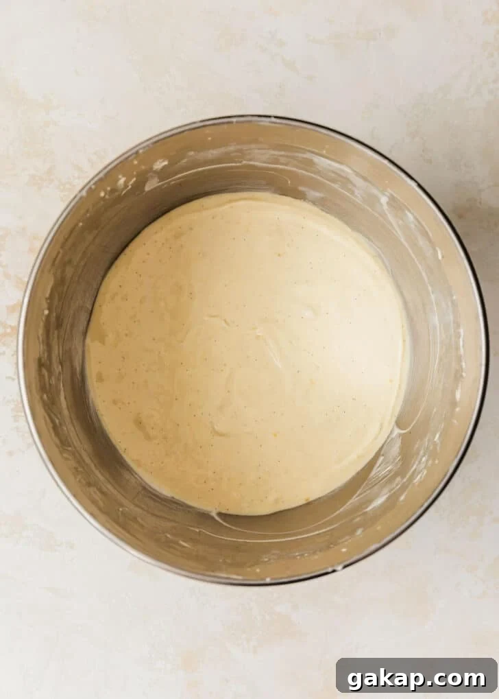A silver bowl of filling for mini creme brulee cheesecakes.