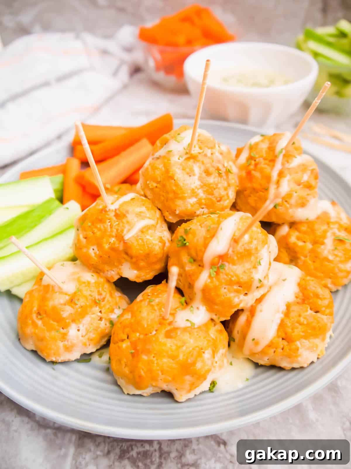 A plate of healthy buffalo meatballs with toothpicks in each one.