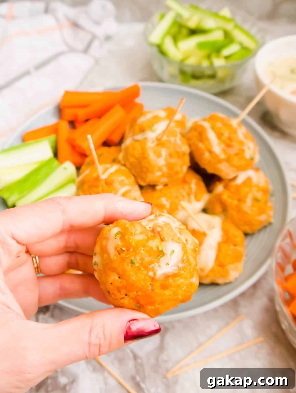 A hand holding a healthy buffalo turkey meatball.