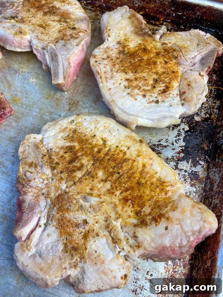 Seared and baked pork chops with a bone lightly browned and cooked to an internal temperature of 145 degrees F