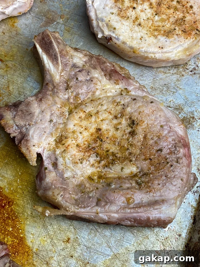 Overhead view of a tender and juicy baked pork loin chop on a baking sheet