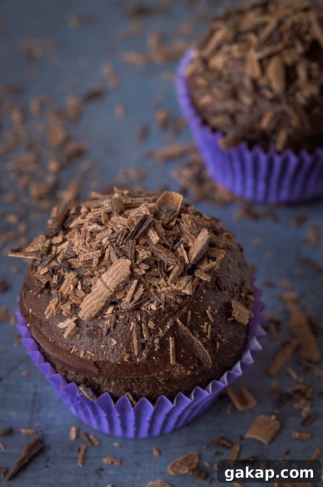 Chocolate cupcakes for two - a small batch of just two delicious vegan chocolate cupcakes that are incredibly quick and easy to whip up and so tasty! Perfect for Valentines Day. #vegan #veganbaking #vegancupcakes #smallbatch Two vegan chocolate cupcakes topped with chocolate shavings.